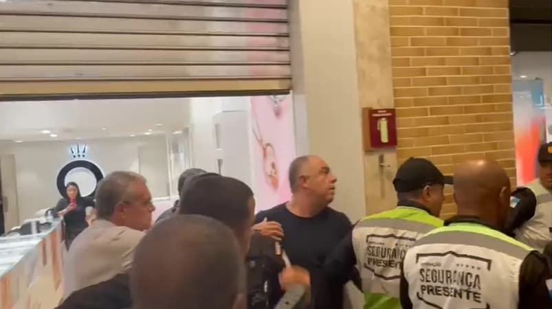 Marcos Braz é cercado por seguranças em frente à loja de shopping do Rio onde se envolveu em episódio de agressão a torcedor