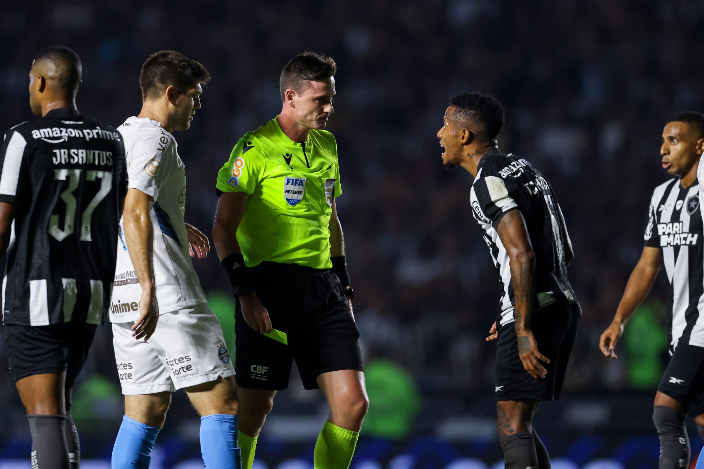 Jogadores de Botafogo e Grêmio em volta do juiz, na partida entre as equipes pelo Brasileirão. Ídolo do Flamengo não se conteve nas redes sociais após nova virada sofrida pelo alvinegro