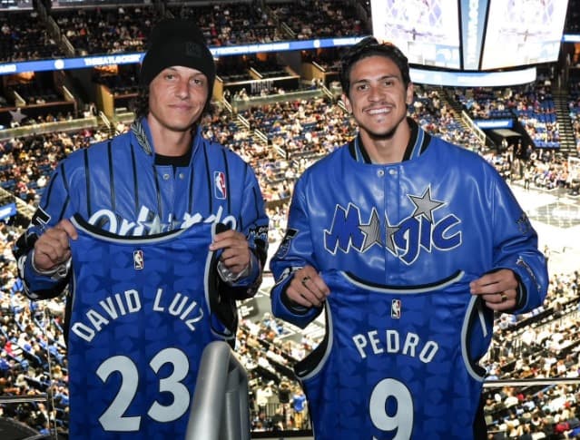 Pedro e David Luiz posam para foto com camisas do Orlando Magic, da NBA