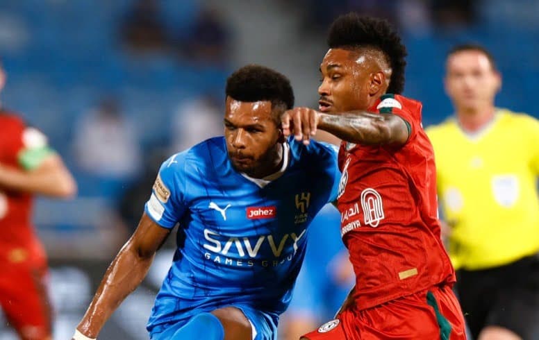 Ali Al Bulayhi do Al Hilal e Vitinho, ex-flamengo, atuando pelo Al-Ettifaq lutam pela bola durante a partida da Saudi Pro League; atacante será emprestado para o Al-Shabab
