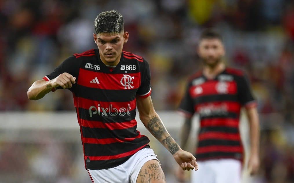Ayrton Lucas conduz a bola sob olhar de Léo Pereira. Flamengo evolui e lterais sobem de produção.