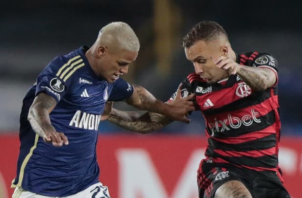 Cebolinha, do Flamengo, disputa bola com jogador do Millonarios