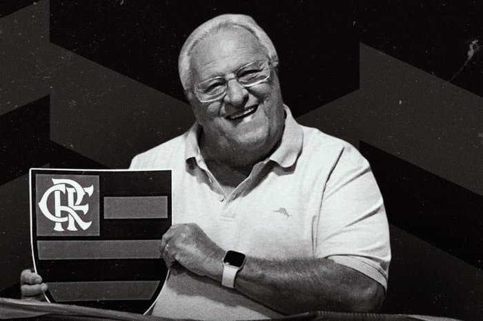 Apolinho segurando escudo do Flamengo; rubro-negro, ex-treinador e ícone da comunicação faleceu no dia 15 de maior de 2024; vitória na Libertadores e as últimas notícias