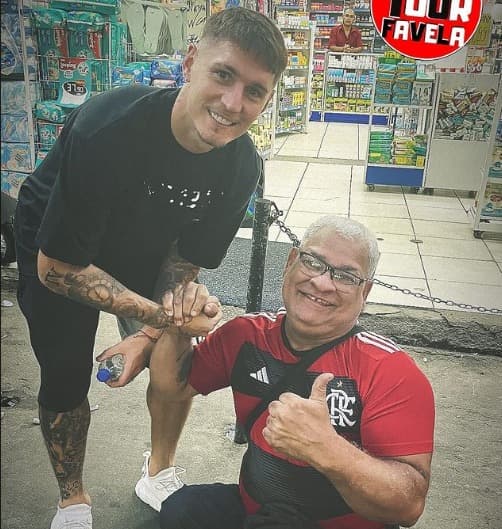 Varela durante tour pela Rocinha em foto com torcedor do Flamengo