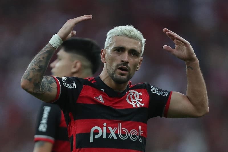 Arrascaeta levanta os braços animando torcida após gol pelo Flamengo; meia costuma se lesionar no segundo semestre