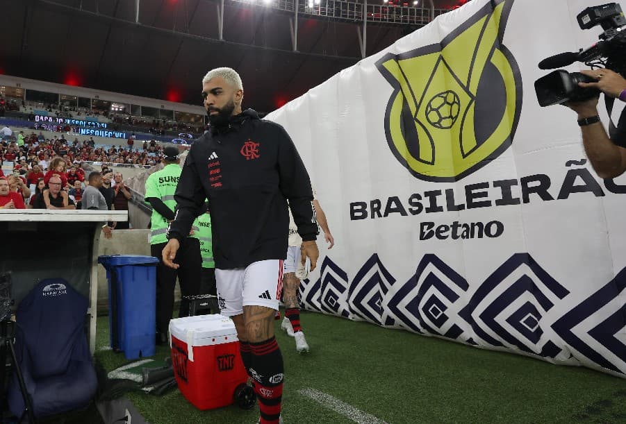 Gabigol entra em campo no Maracanã em dia de jogo do Flamengo; ao fundo, banner com logo do Brasileirão 2024