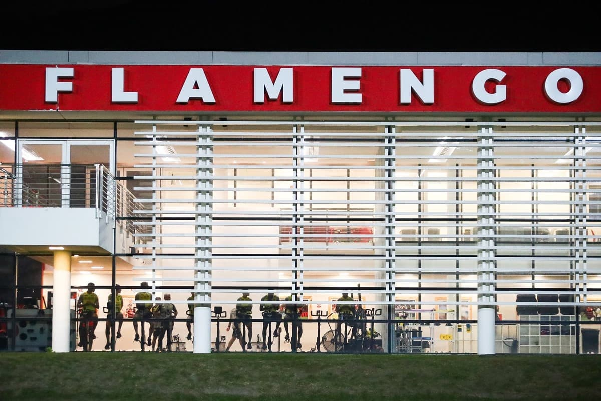 Fachada da academia do Ninho do Urubu, centro de treinamento do Flamengo. Na parte interna, atletas pedalam durante processo de recuperação
