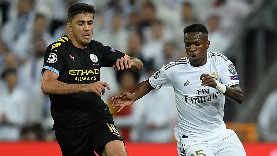 O atacante brasileiro do Real Madrid, Vinicius Junior (R), desafia o meio-campista espanhol do Manchester City, Rodri, durante a partida de ida das oitavas de final da Liga dos Campeões da UEFA entre Real Madrid CF e Manchester City, no estádio Santiago B