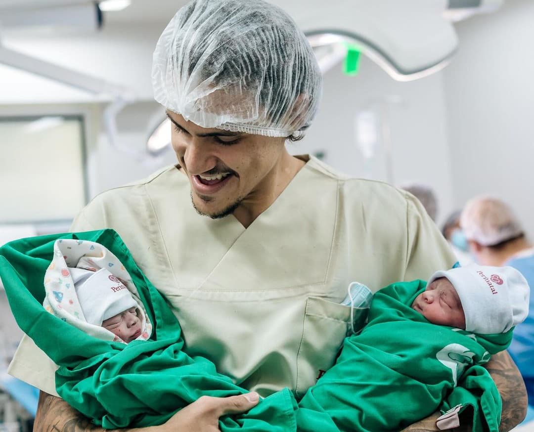 Pedro segura suas filhas gêmeas, Isabela e Antônia