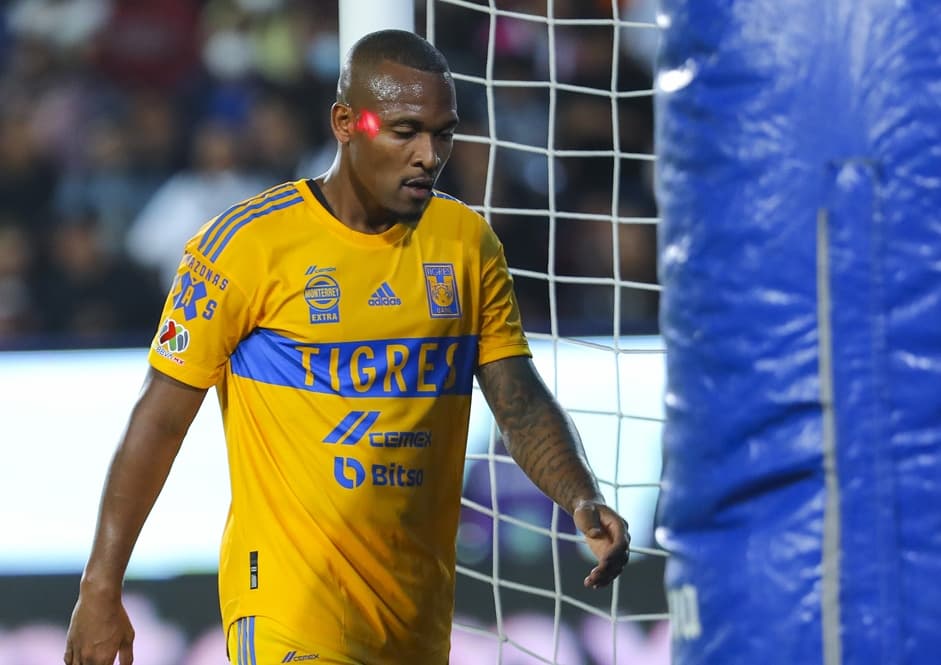 Samir cabisbaixo durante jogo do Tigres, do México, com laser vermelho no seu rosto