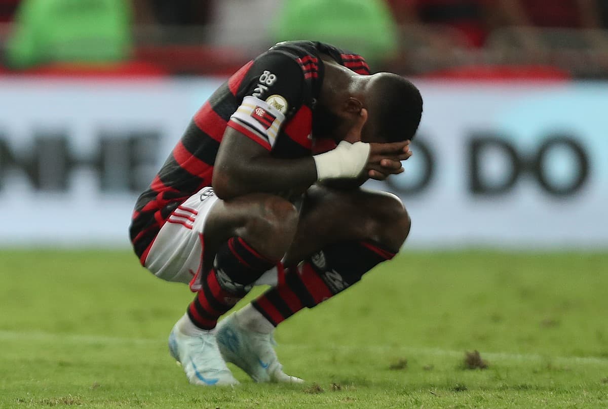 Gerson agachado com mãos na cabeça exprimindo exaustão após jogo do Flamengo
