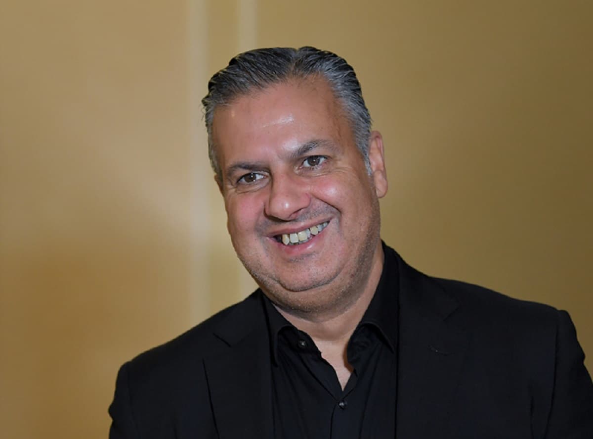 Vestido de preto, José Boto sorri durante entrevista