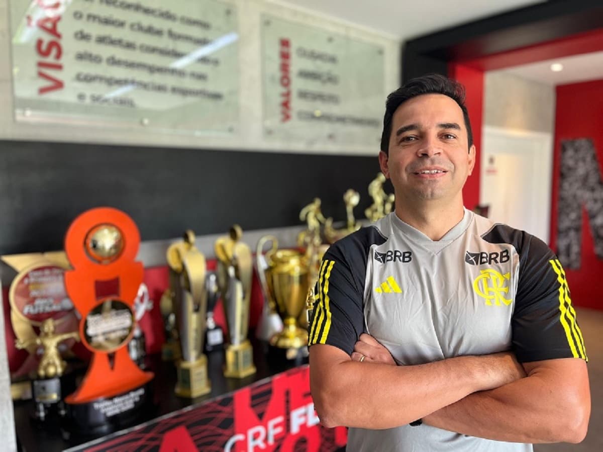 Cleber dos Santos posa para foto ao lado de troféus no retorno ao Flamengo