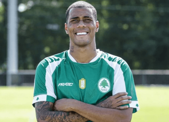 Alyson, jogador do Boavista, sorri de braços cruzados