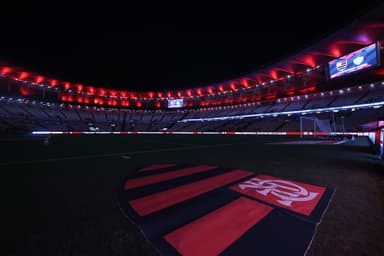 Escudo do Flamengo no gramado Maracanã iluminado com as cores vermelha e preta