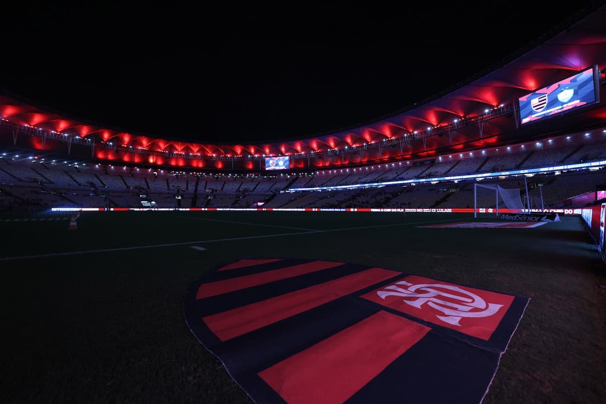 Escudo do Flamengo no gramado Maracanã iluminado com as cores vermelha e preta