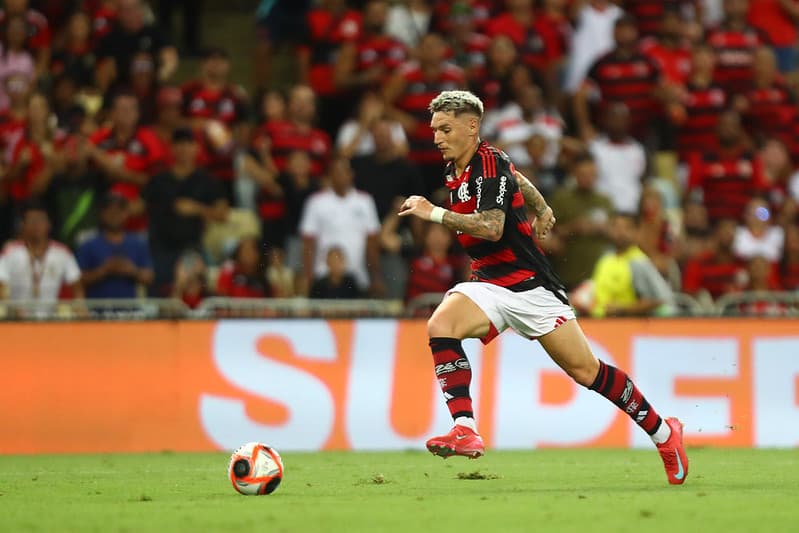 Varela conduz bola pelo Flamengo com torcedores ao fundo