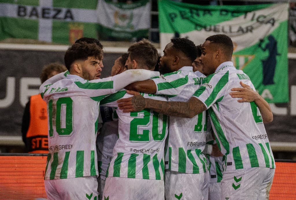 Time do Betis abraçado comemorando gol