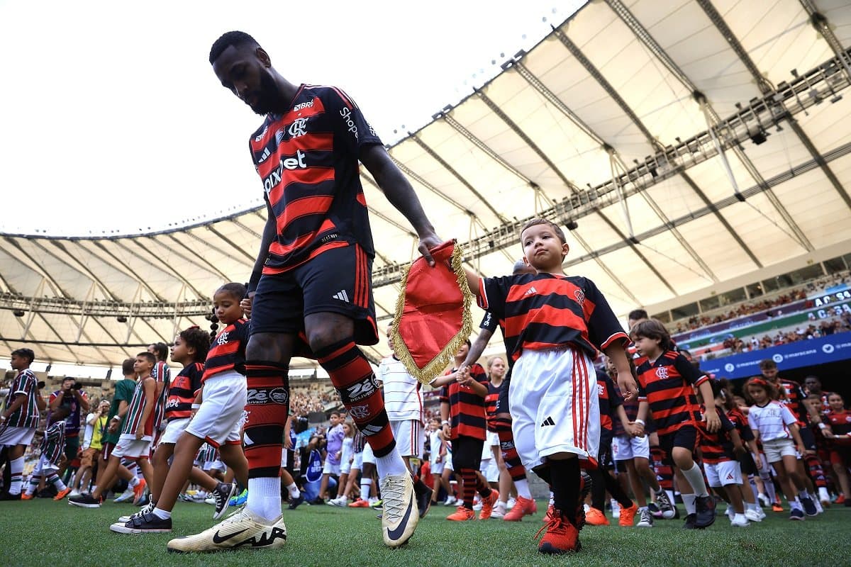 Gerson caminha ao lado de criança em entrada no campo para o clássico