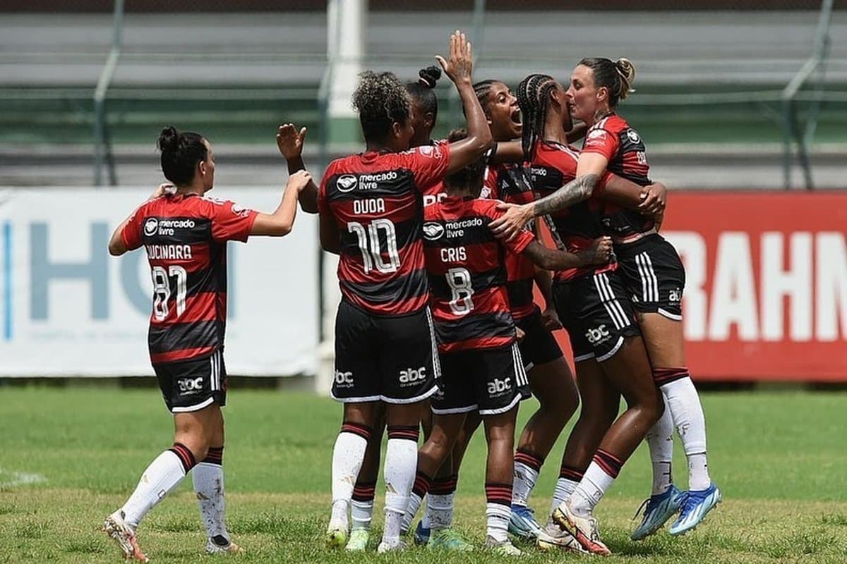 Sete jogadoras do Flamengo se abraçam, em comemoração dentro de campo