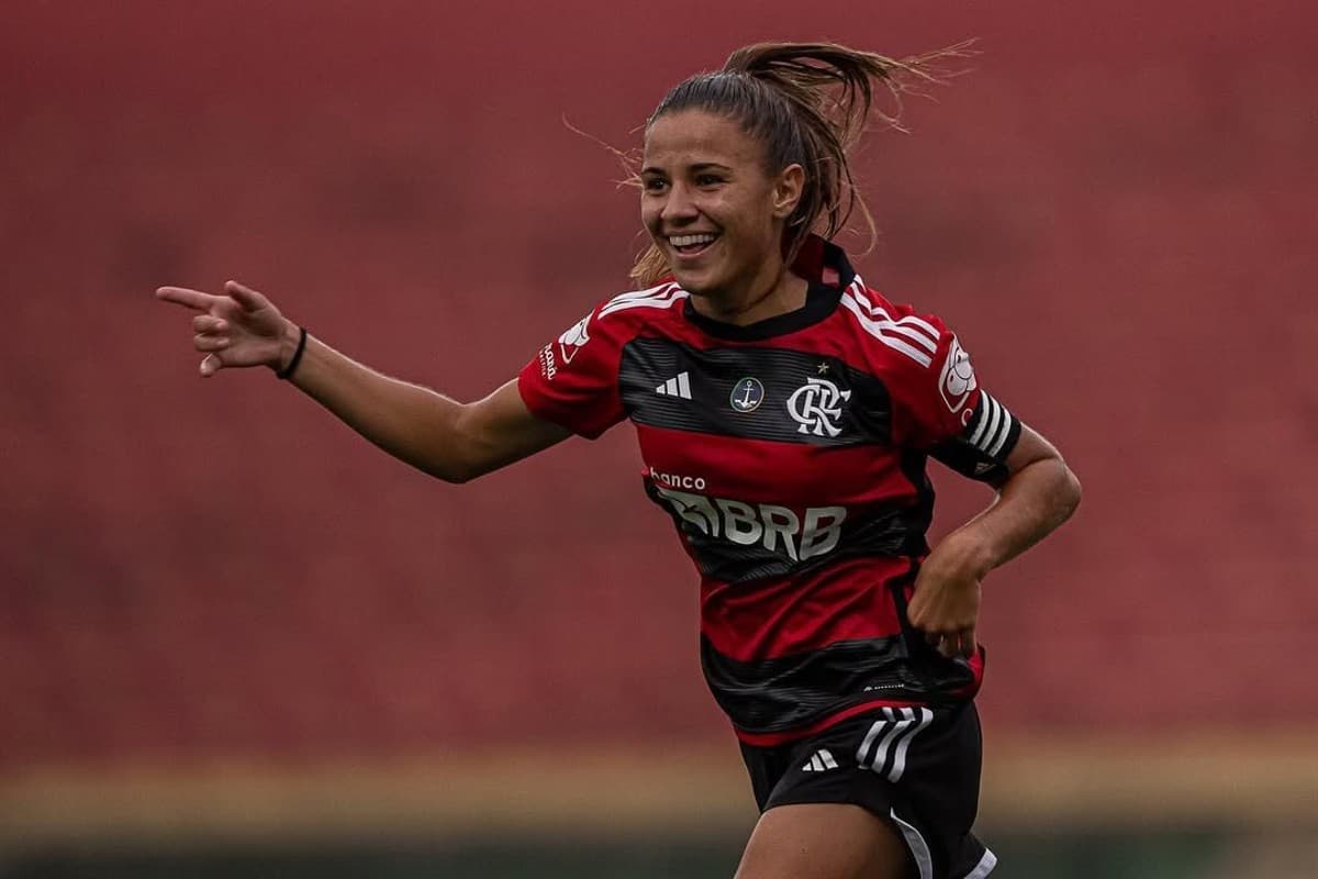 A atacante Mariana Fernandes sorri e comemora após gol, ela está correndo e apontando