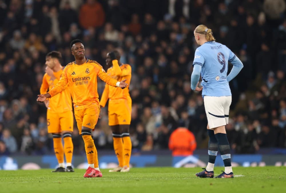 MANCHESTER, INGLATERRA - 11 DE FEVEREIRO: Vinicius Junior, do Real Madrid, reage a Erling Haaland, do Manchester City, depois que Erling Haaland marcou o primeiro gol de seu time durante a partida de ida da eliminatória da Liga dos Campeões da UEFA 2024/2