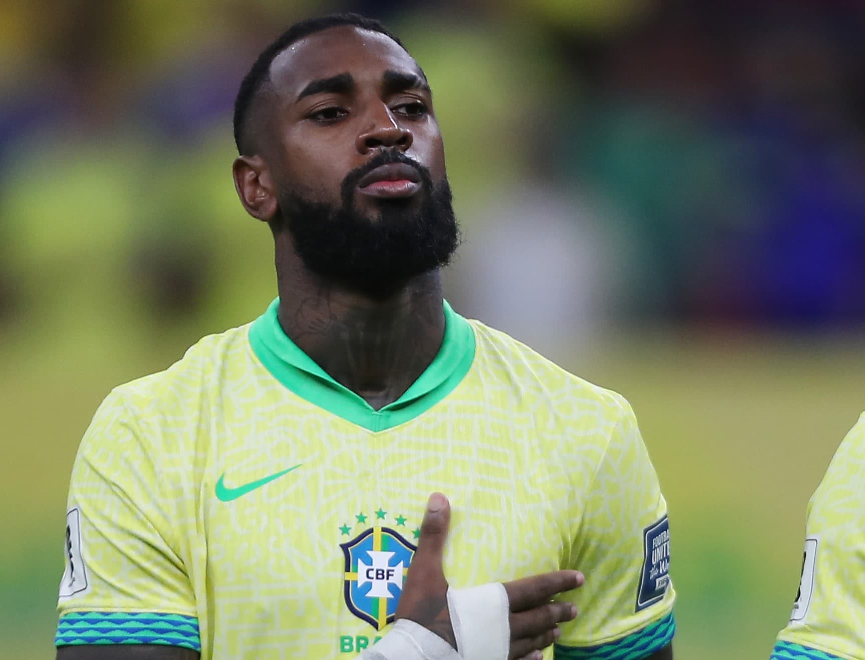 Gerson perfilado durante hino em jogo do Brasil F