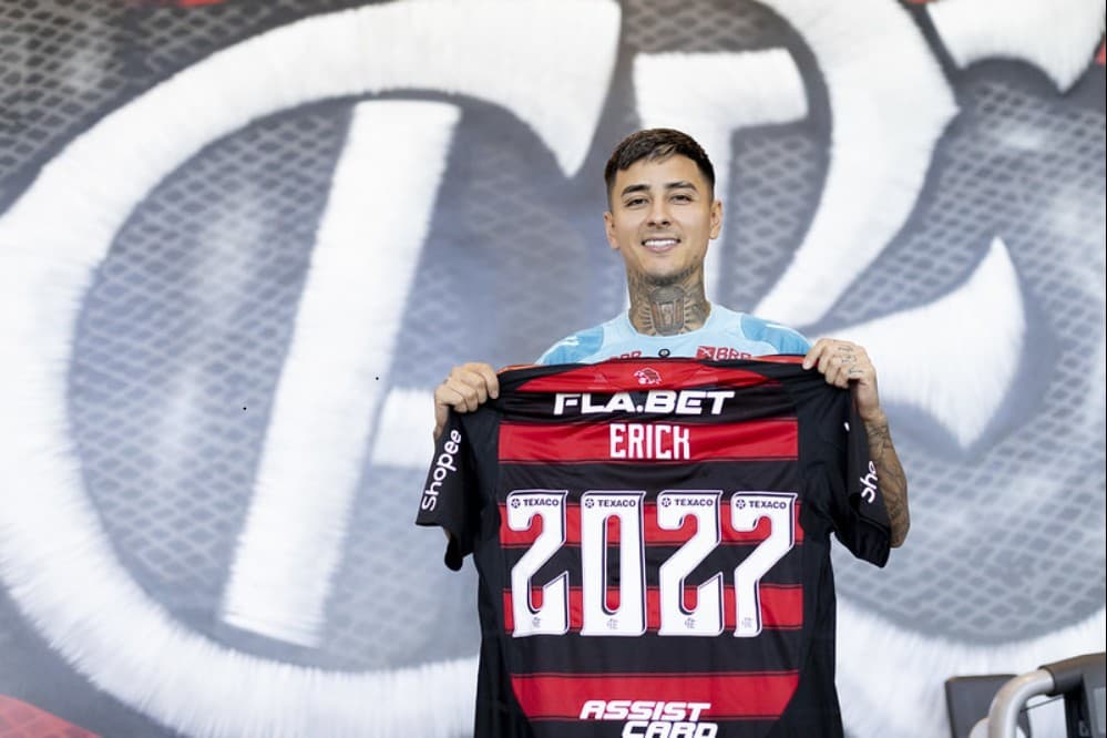 Pulgar segurando camisa do Flamengo com número 2027