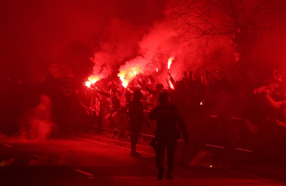 Torcedores acendem sinalizadores do lado de fora do estádio enquanto esperam a chegada dos jogadores antes da partida de volta das oitavas de final da Liga dos Campeões da UEFA 2024/25 entre Atlético de Madrid e Real Madrid C.F. no Estádio Metropolitano e
