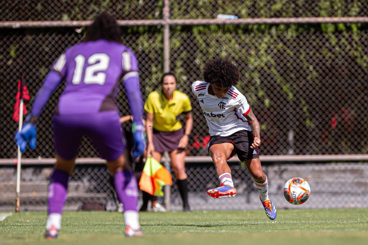 Valéria Cantuário recebe a bola cara cara com a goleira do Botafogo, ao fundo é possível ver a bandeirinha acompanhando atentamente o lance