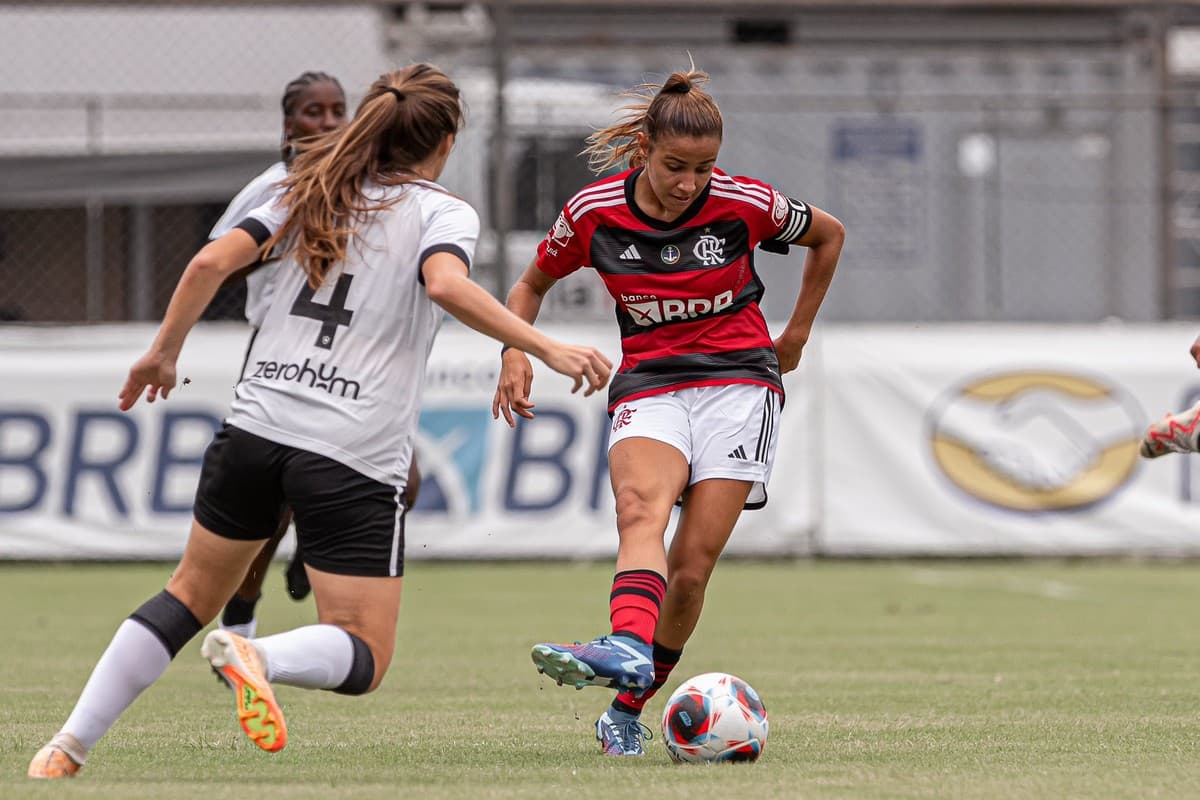 Mariana Fernandes conduz a bola e é marcada por jogadora do Botafogo