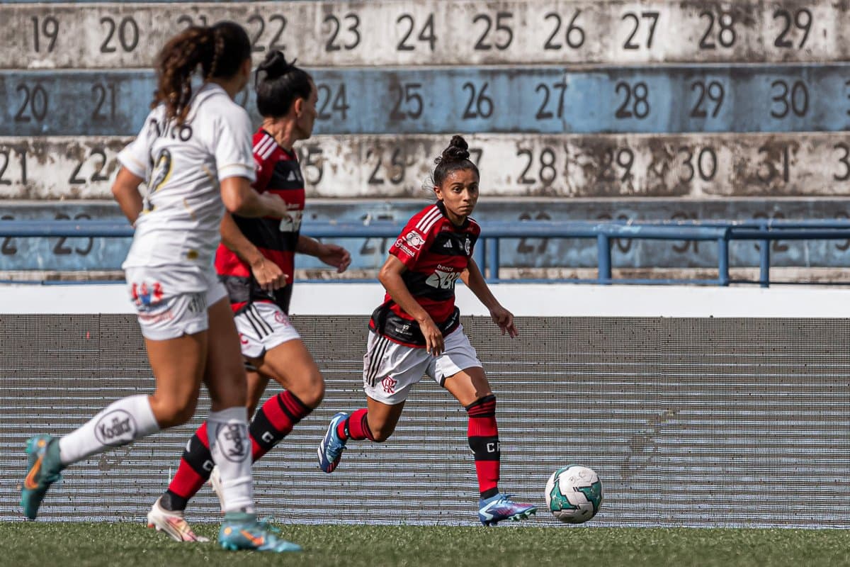 Gisseli conduz a bola e é acompanhada por Jucinara e uma marcadora do Santos