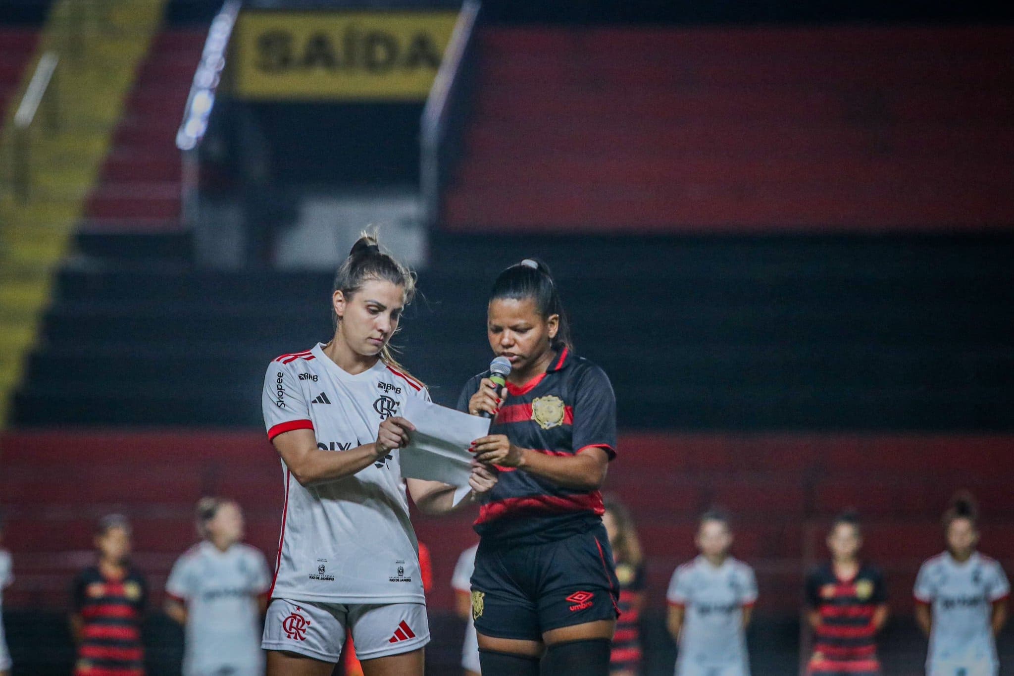 Imagem das atletas lendo a mensagem.