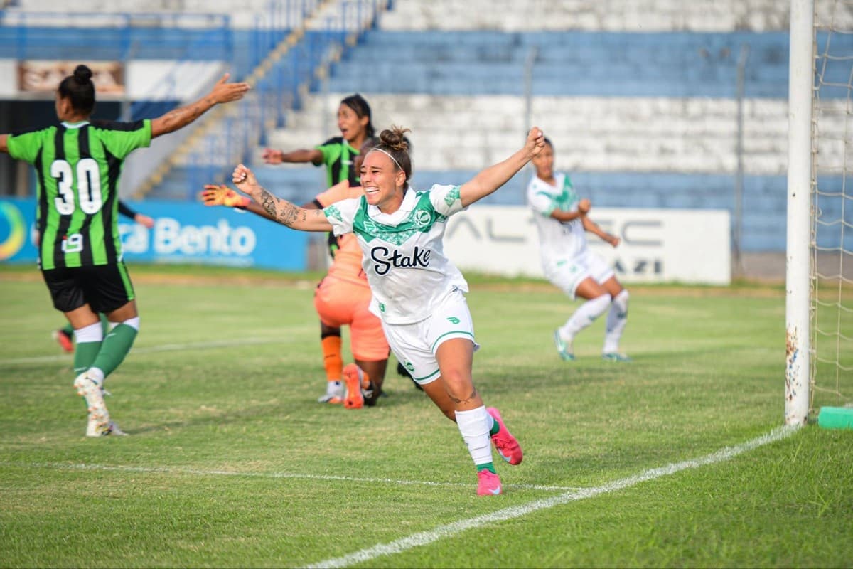 Uma jogadora do Juventude comemora gol na partida contra o América-MG, ela corre de braços abertos e sorri