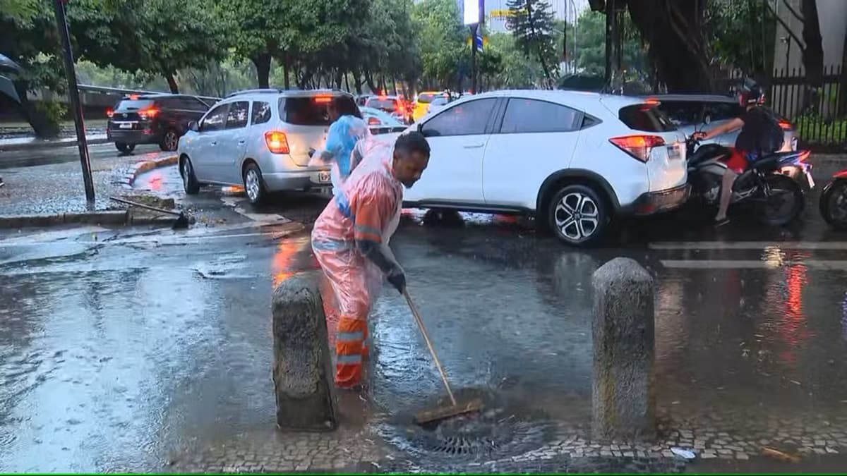 Trabalhador da Prefeitura tenta ajudar no escoamento da água no Rio de Janeiro