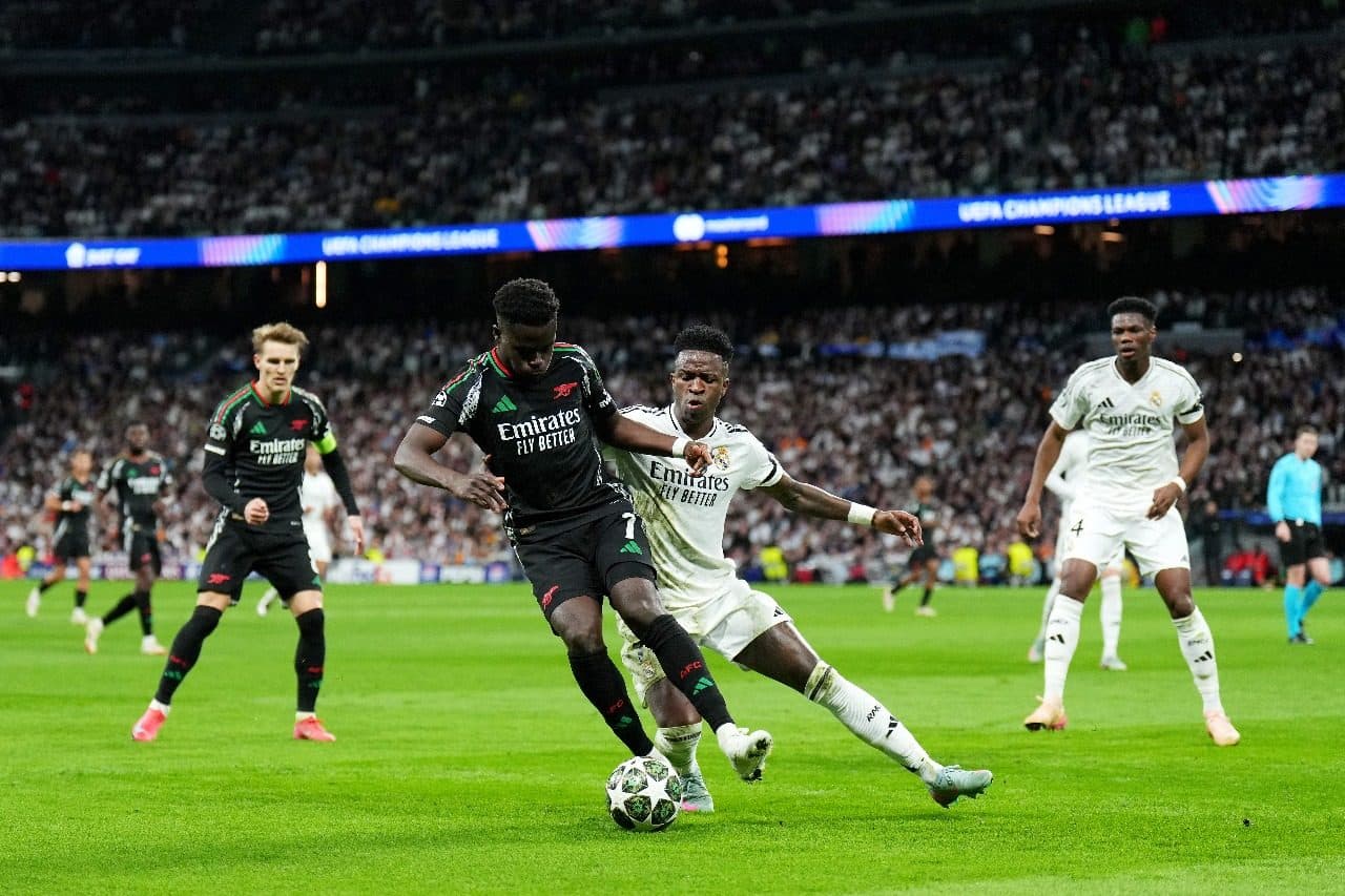 Bukayo Saka, do Arsenal, é desafiado por Vinicius Junior, do Real Madrid, durante a partida de volta das quartas de final da Liga dos Campeões da UEFA 2024/25 entre Real Madrid C.F. e Arsenal FC, no Estádio Santiago Bernabeu, em 16 de abril de 2025 em Mad
