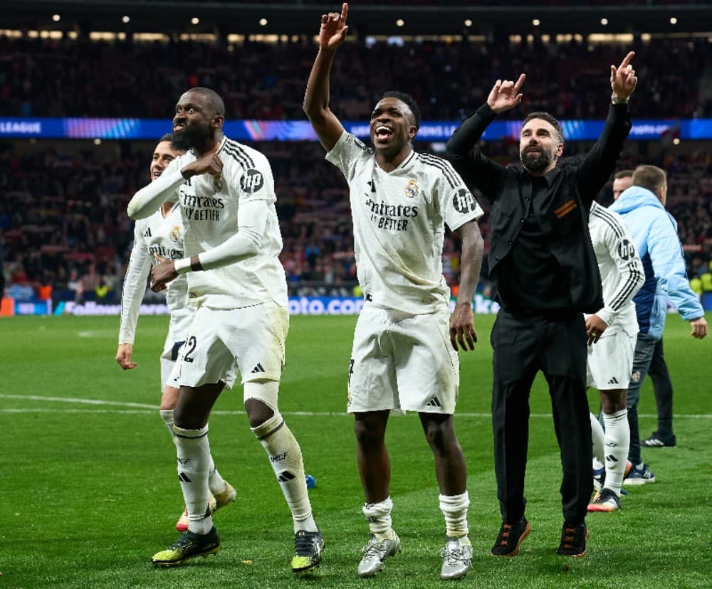 Antonio Ruediger, Vinicius Junior e Daniel Carvajal, do Real Madrid, comemoram a vitória após o Real Madrid derrotar o Atlético de Madrid nos pênaltis durante a partida de volta das oitavas de final da Liga dos Campeões da UEFA 2024/25 entre o Atlético de