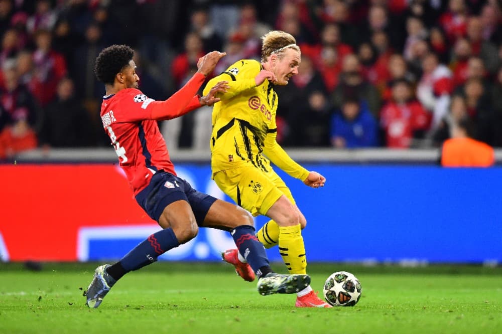 Julian Brandt, do Borussia Dortmund, é desafiado por Alexsandro, do LOSC Lille, durante a partida de volta das oitavas de final da Liga dos Campeões da UEFA 2024/25 entre LOSC Lille e Borussia Dortmund no Stade Pierre Mauroy em 12 de março de 2025 em Lill