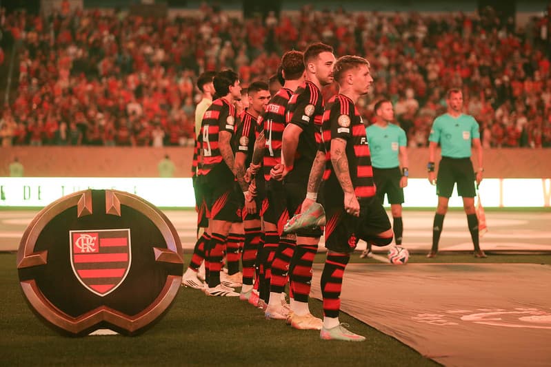 Jogadores perfilados em frente à placa com escudo do Flamengo antes da estreia na Copa do Mundo de Clubes