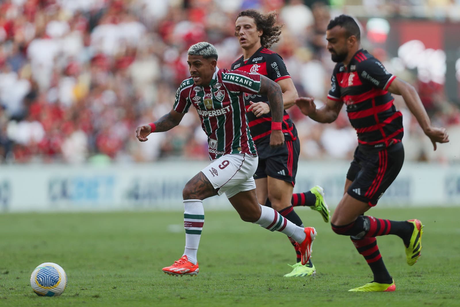 John Kennedy, do Fluminense, disputa a bola com David Luiz, do Flamengo, durante a partida entre Fluminense e Flamengo no Brasileirão 2024, no Estádio do Maracanã, em 23 de junho de 2024, no Rio de Janeiro, Brasil.
