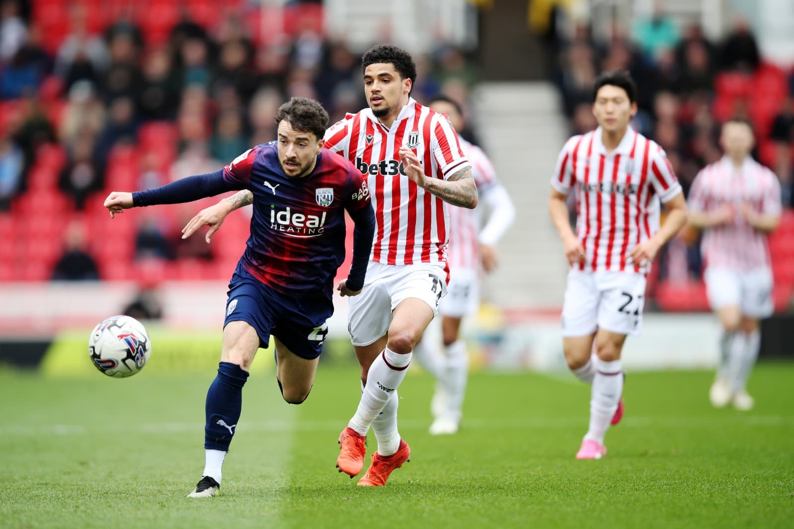 Mikey Johnston, do West Bromwich Albion, é desafiado por Ki-Jana Hoever, do Stoke City, durante a partida do Sky Bet Championship entre Stoke City e West Bromwich Albion no Bet365 Stadium em 6 de abril de 2024 em Stoke on Trent, Inglaterra.