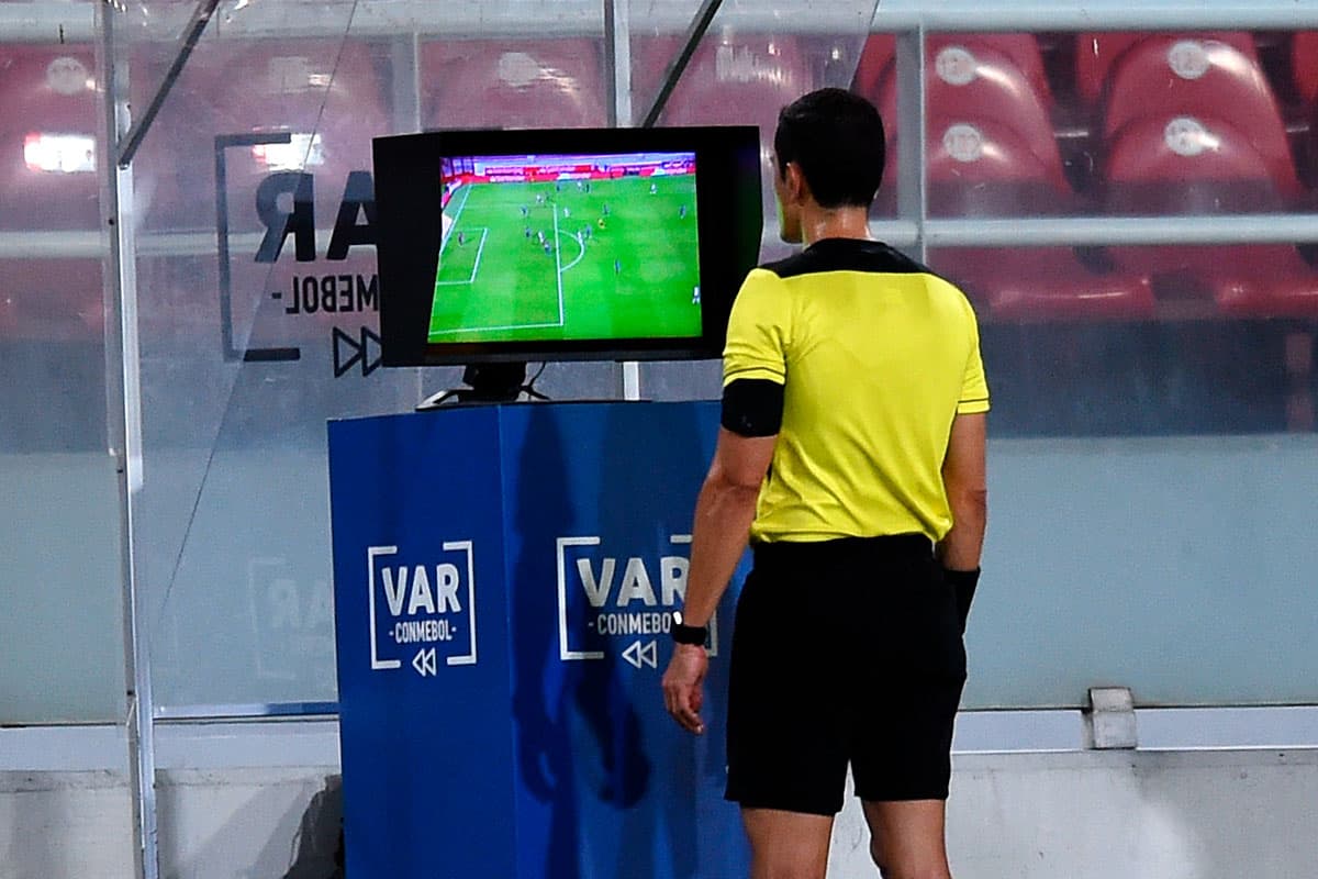 O árbitro Andrés Rojas checa o VAR para marcar um pênalti para o River Plate durante uma partida de ida entre River Plate e Nacional como parte das quartas de final da Copa CONMEBOL Libertadores 2020.