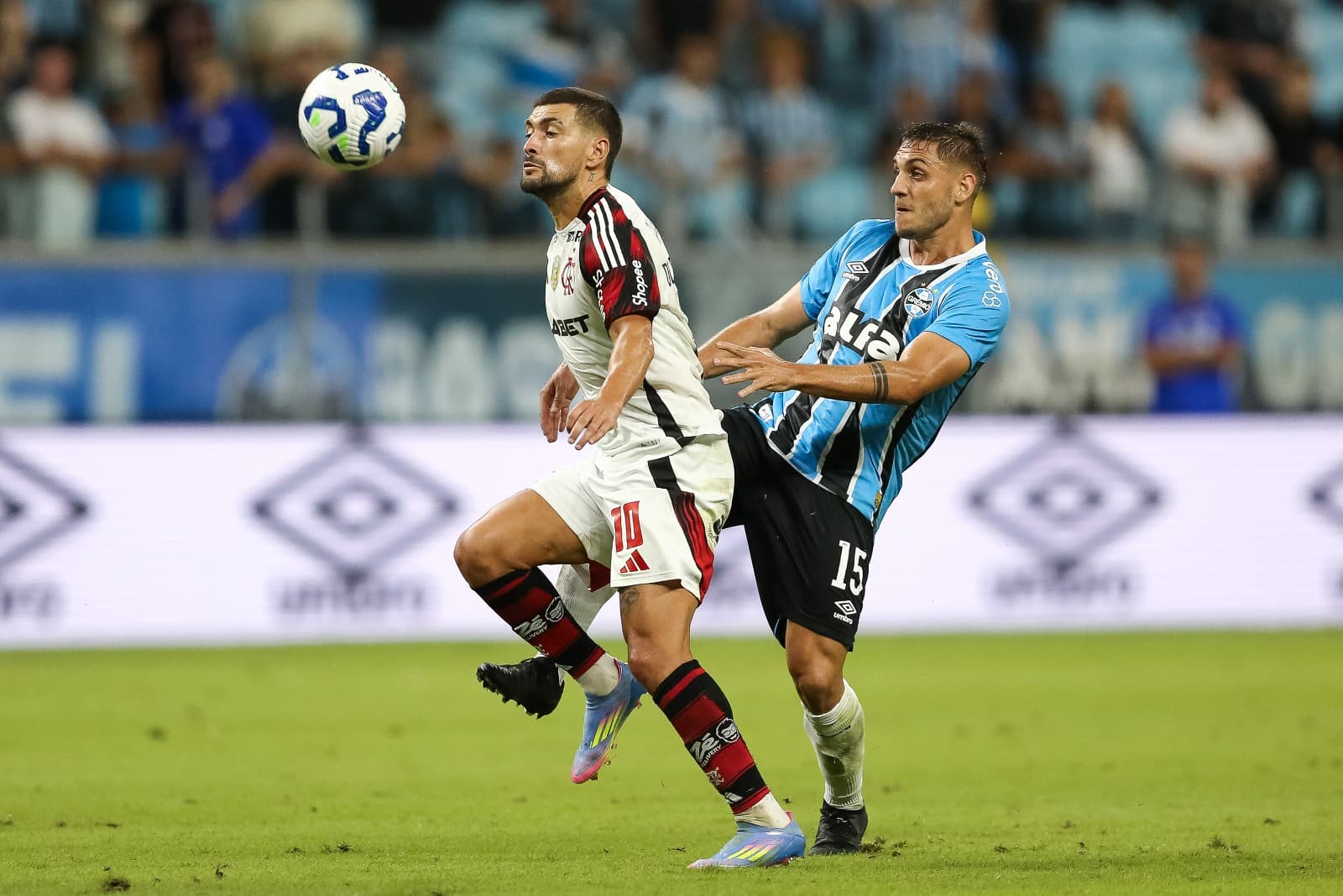Camilo Reijers do Grêmio e Giorgian de Arrascaeta do Flamengo disputam a bola durante a partida entre Grêmio e Flamengo no Brasileirão 2025 na Arena do Grêmio em 13 de abril de 2025 em Porto Alegre, Brasil.