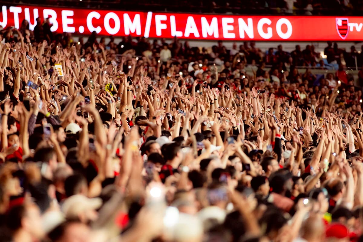 Torcida do Flamengo ergue as mãos para o alto durante jogo contra o Vitória, no Maracanã