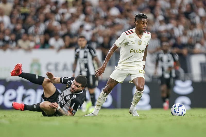 Bruno Henrique com a bola dominada, enquanto volante do Ceará observa caído