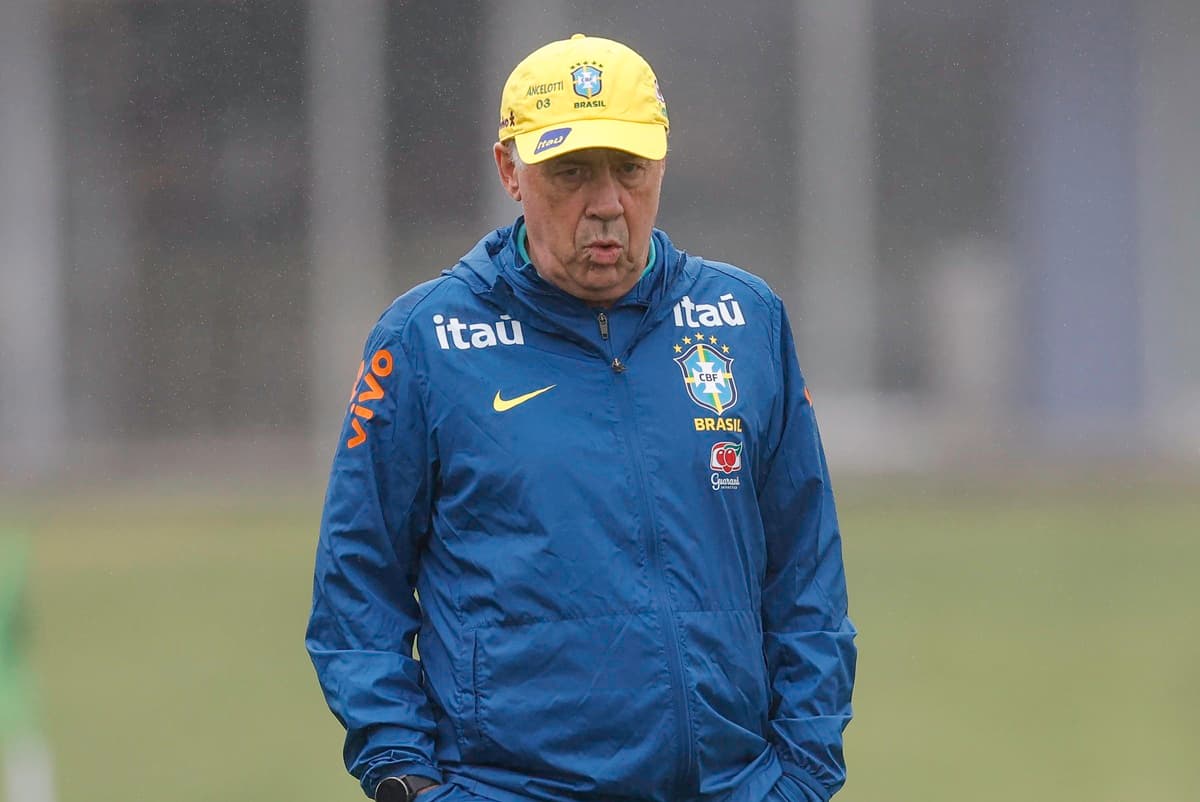 Vestido com o uniforme de treino do Brasil, Carlo Ancelotti olha para baixo enquanto caminha pelo campo na Granja Comary