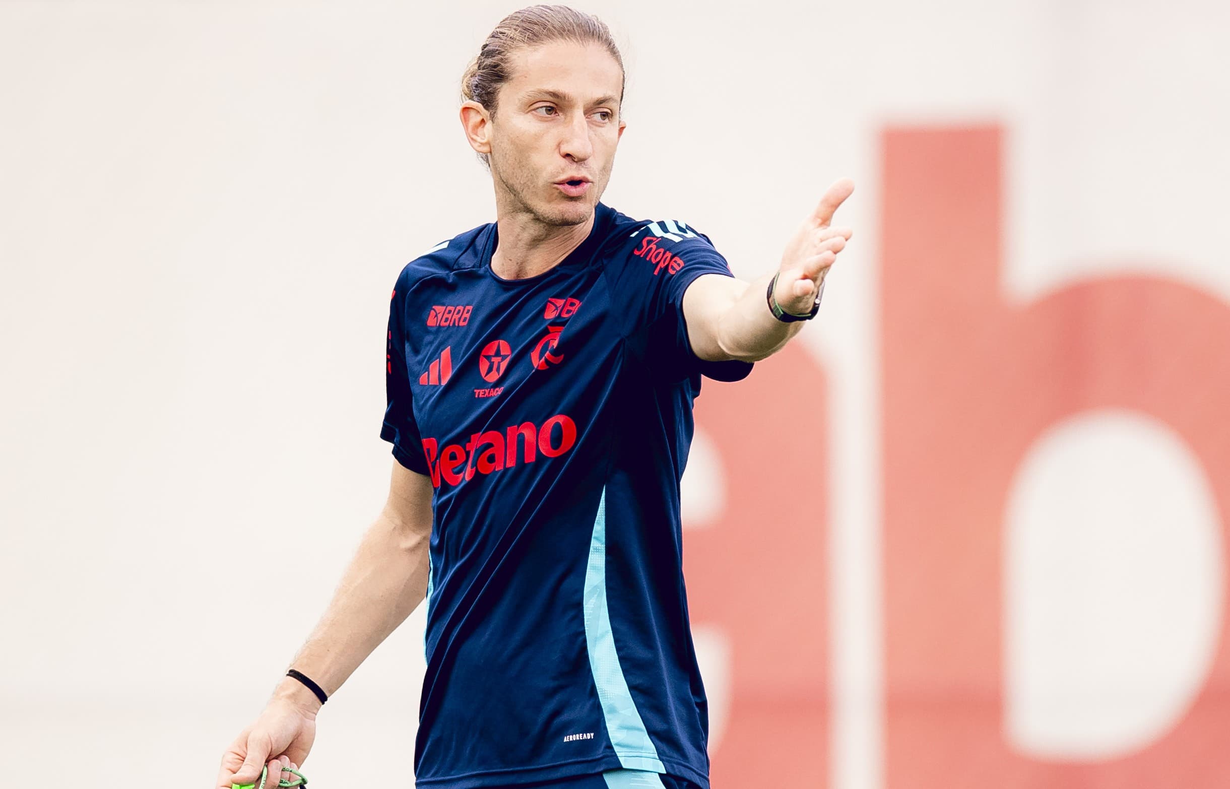 Filipe Luís aponta com a mão esquerda para dar instrução a jogador em treino no Ninho do Urubu