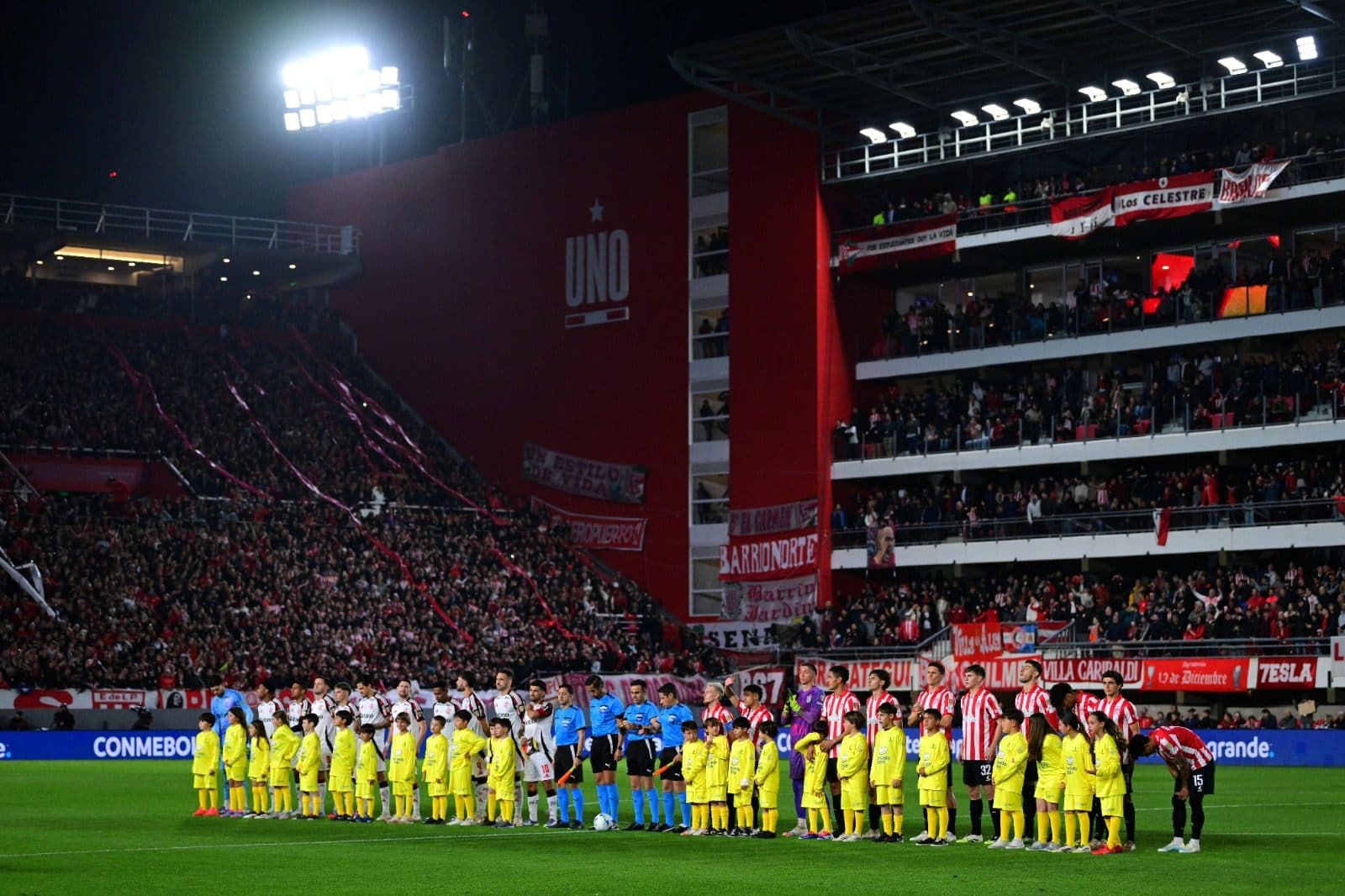 Jogadores e árbitros se alinham antes da partida de volta das quartas de final da Copa CONMEBOL Libertadores 2025, no Estádio Jorge Luis Hirschi, em 25 de setembro de 2025, em La Plata, Argentina.