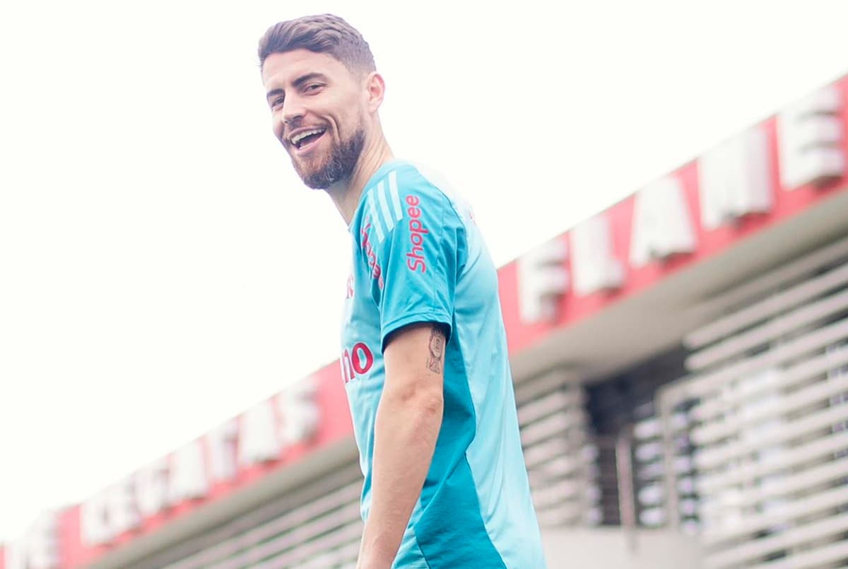 Jorginho sorri para a câmera ao pisar no campo do Ninho do Urubu