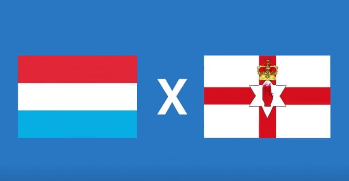 Bandeiras de Luxemburgo e Irlanda do Norte lado a lado sobre fundo azul, separadas por um X branco centralizado, representando o confronto nas Eliminatórias da Copa do Mundo 2026.